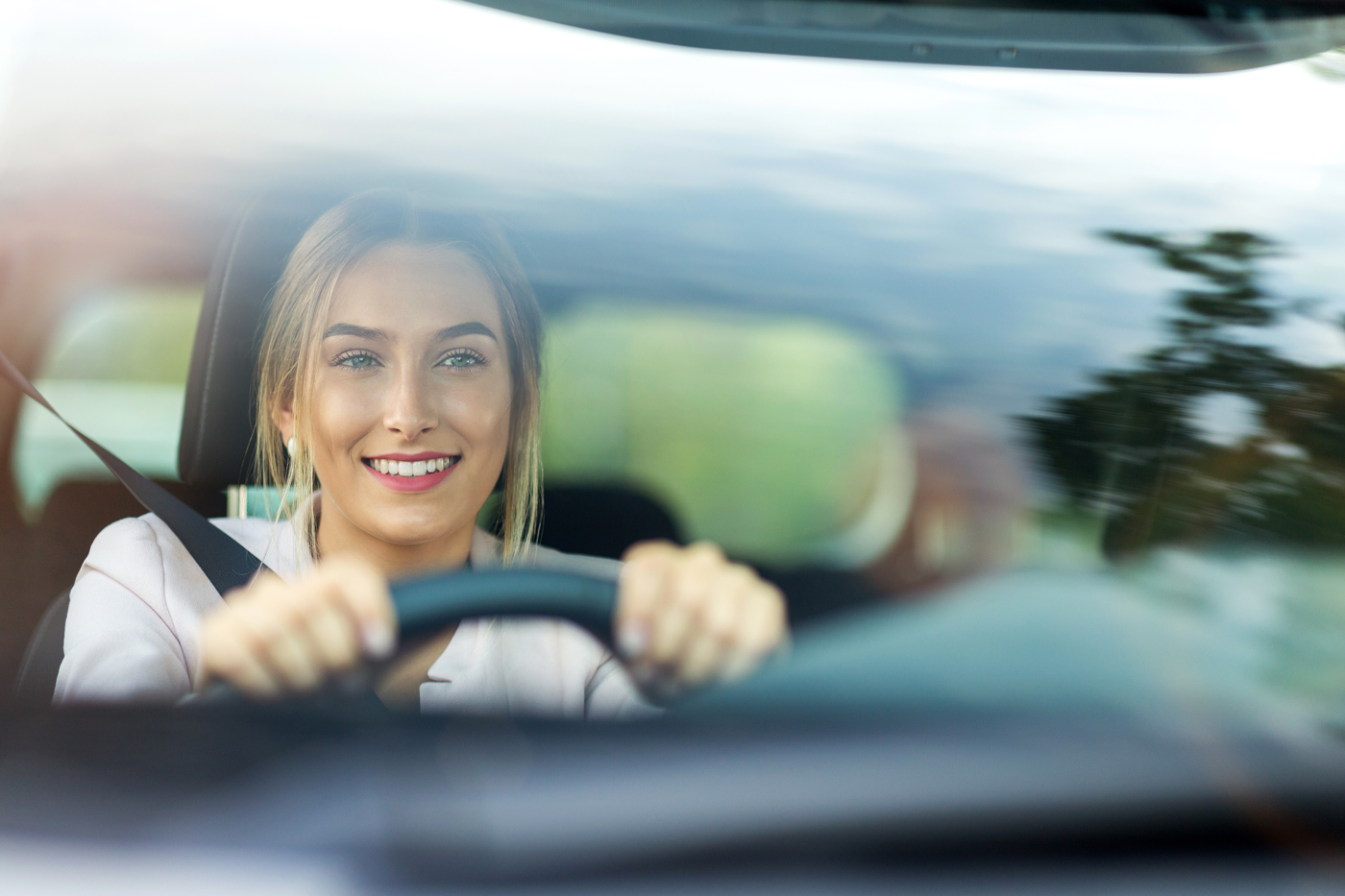 A young woman driving a car smiling