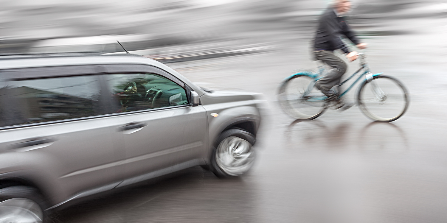 grey-car-close-to-crashing-into-man-on-a-bike.jpg